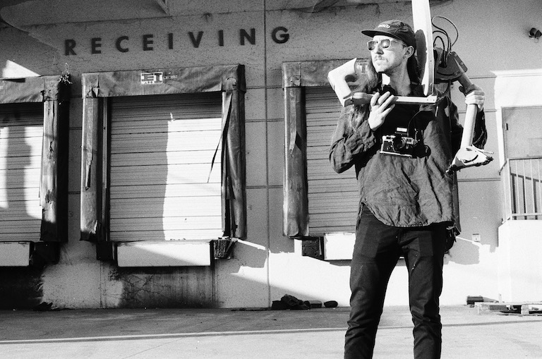 A portrait of Daniel holding a satellite dish to recieve transmissions from the world.